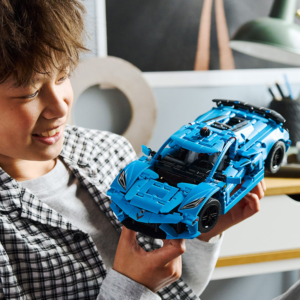 Boy playing with the LEGO Technic Blue Corvette Stingray C8 Toy Car Model Building Kit
