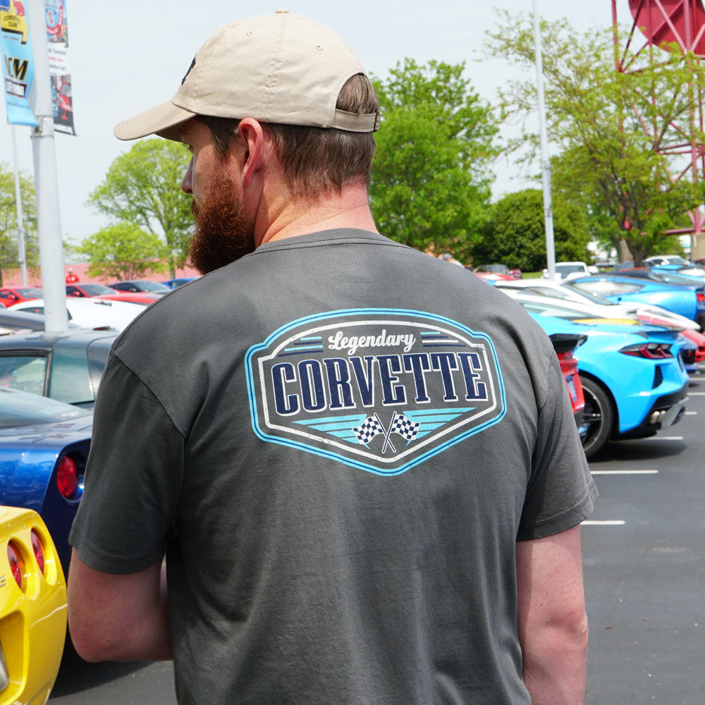 Man wearing the Legendary Corvette Graphite Pocket T-shirt standing in front of a row of parked Corvettes