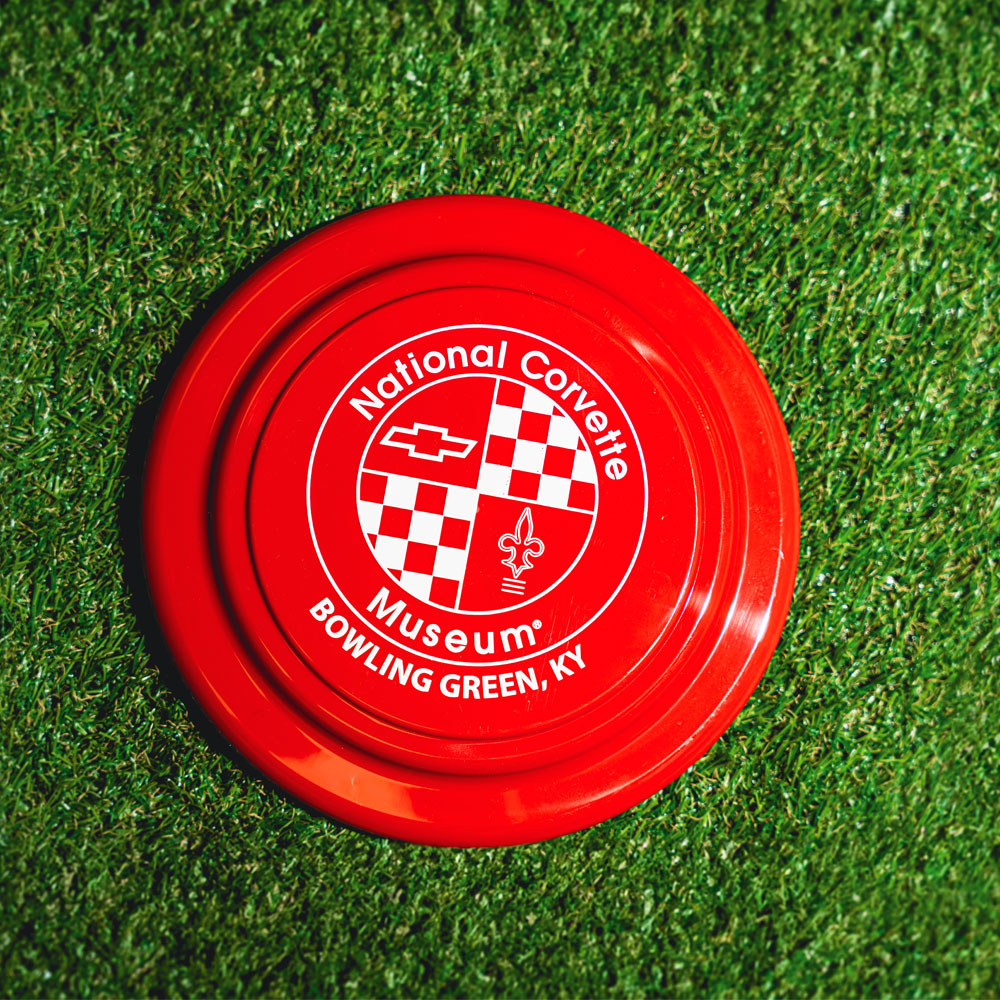 NCM Red Frisbee pictured laying in the grass