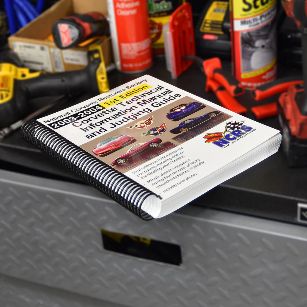 The NCRS 2003-2004 Corvette Technical Guide placed on a tool chest in a garage