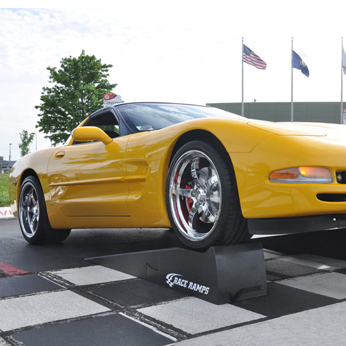 Images shows a yellow Corvette parked on top of the two piece Race Ramps XT 67 Inch 